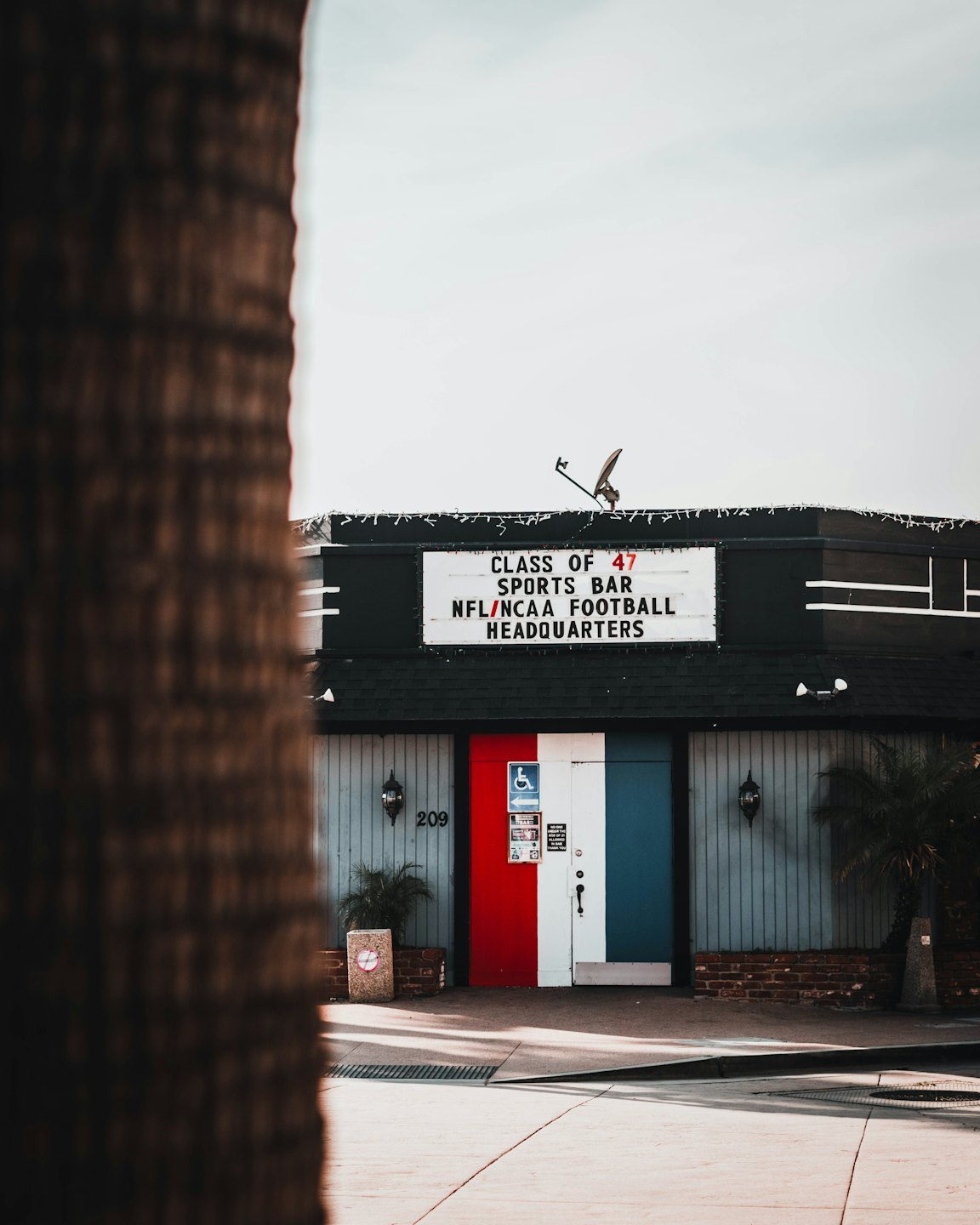 Sports bar with a large sign and red, white, and blue doors.