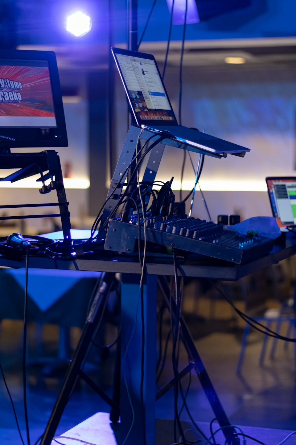 Karaoke monitor, laptop, and audio mixer with cables.