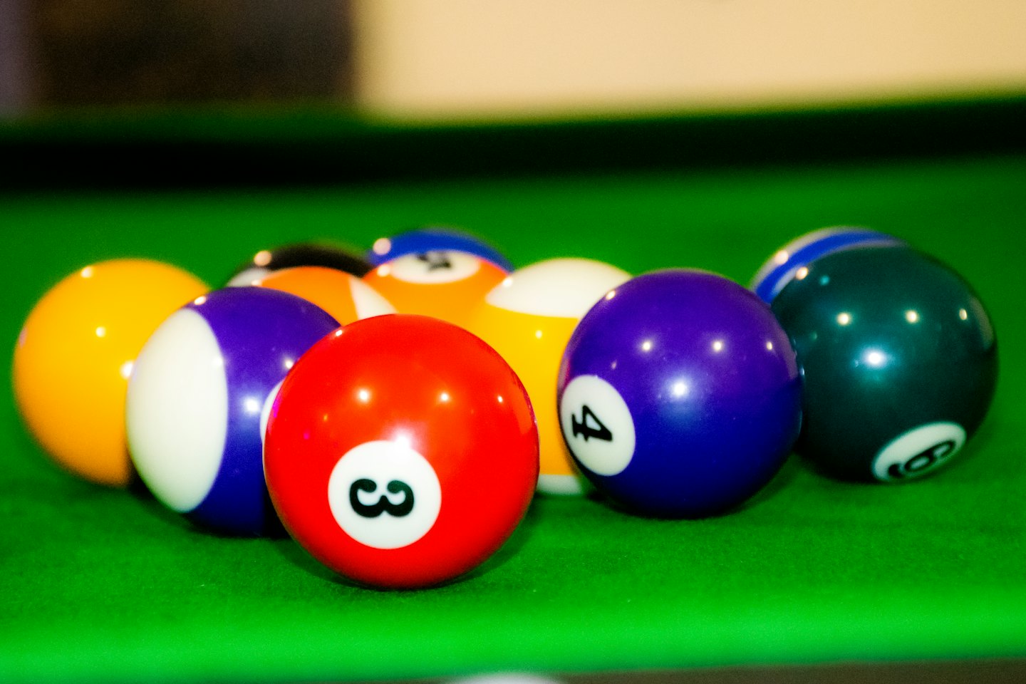 Colorful numbered billiard balls rest on a green felt table.